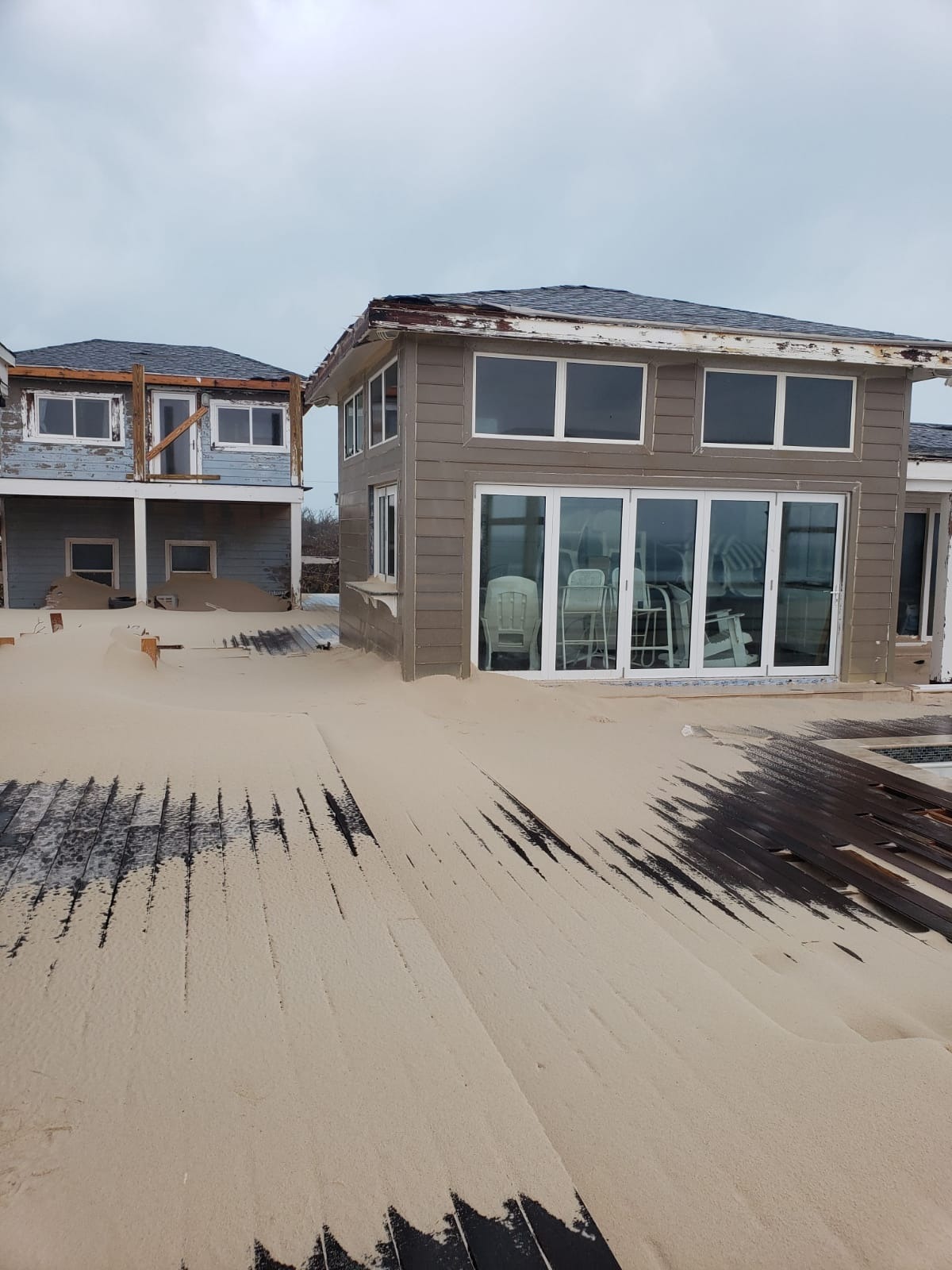 The kitchen door and window with sand deposited around the home.