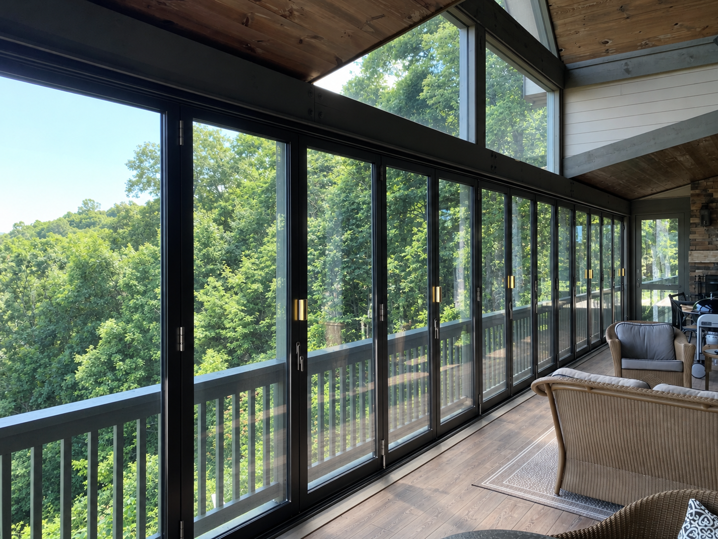 Closed black aluminum folding glass doors overlooking a wooded landscape