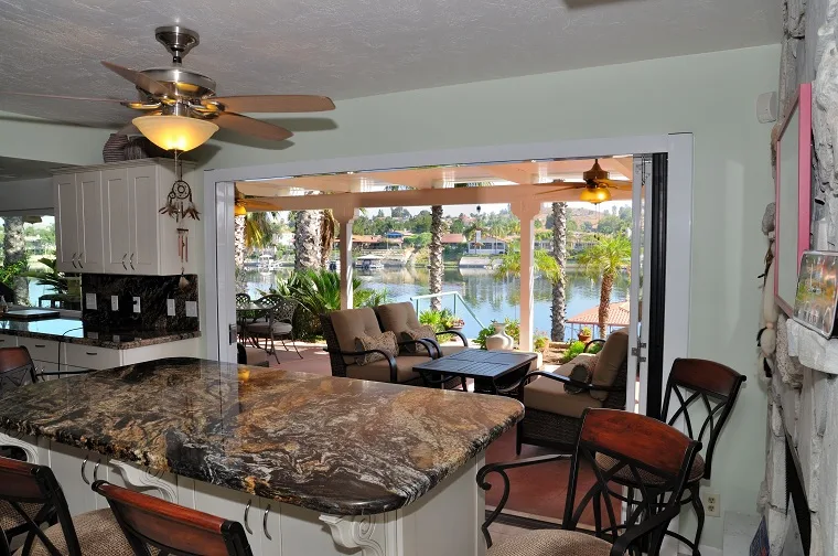 Kitchen and living area connected to a covered patio through a wide folding opening