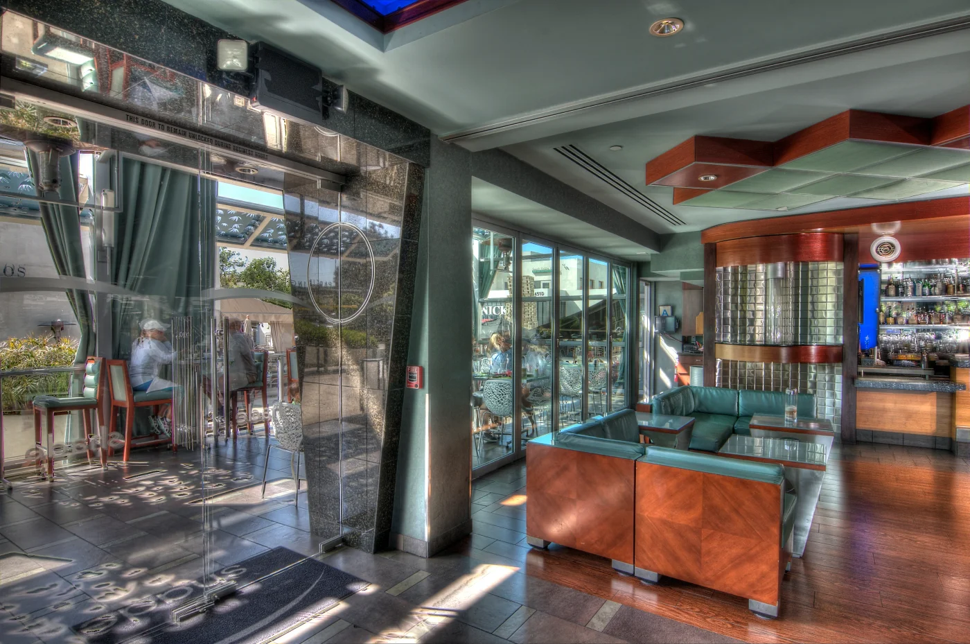 Lanai folding glass doors connecting a hotel dining area to an outdoor courtyard