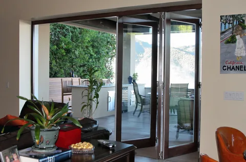Open clad door panels beside a living-room seating area.