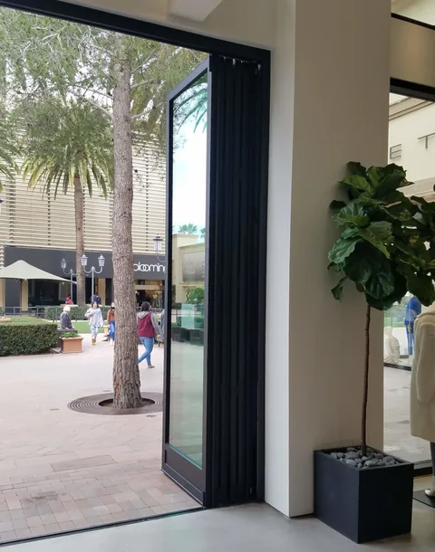 Folded aluminum panels viewed from inside a retail entrance.