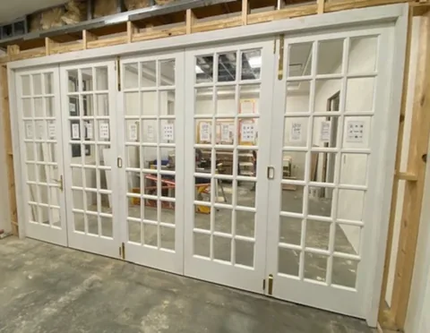 White wood folding panels with divided glass lites.