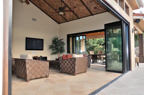 Open folding doors connecting a furnished room to the lawn.