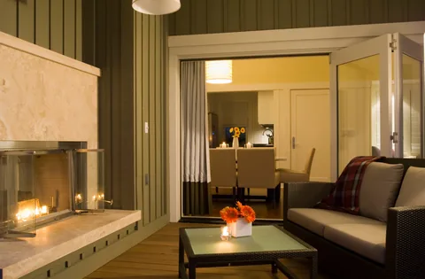 Clad folding doors beside a fireplace in a hospitality lounge.