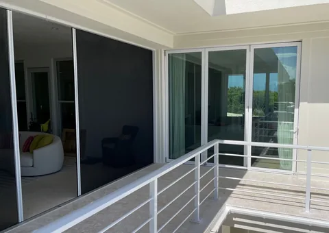 A retractable screen spanning a home’s balcony opening.