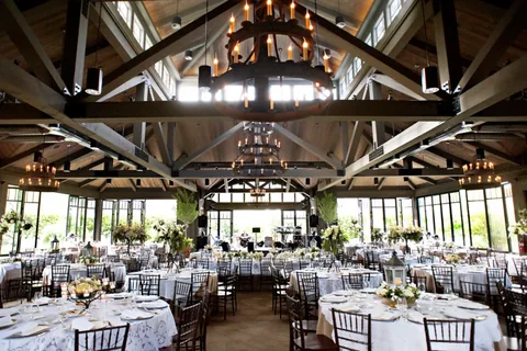 Open folding glass walls surrounding a timber-roofed reception space.