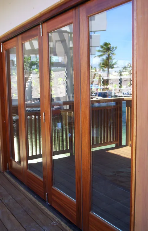 Wood-framed folding panels along a covered visitor walkway.