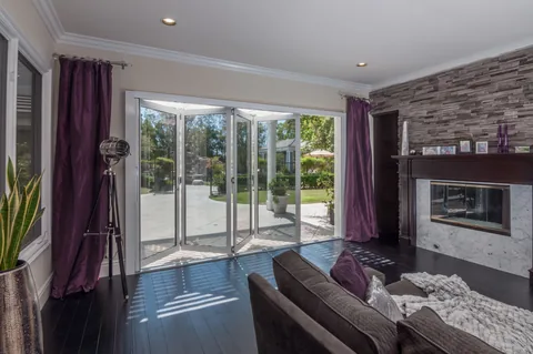 A living room opening toward a garden through folding doors.