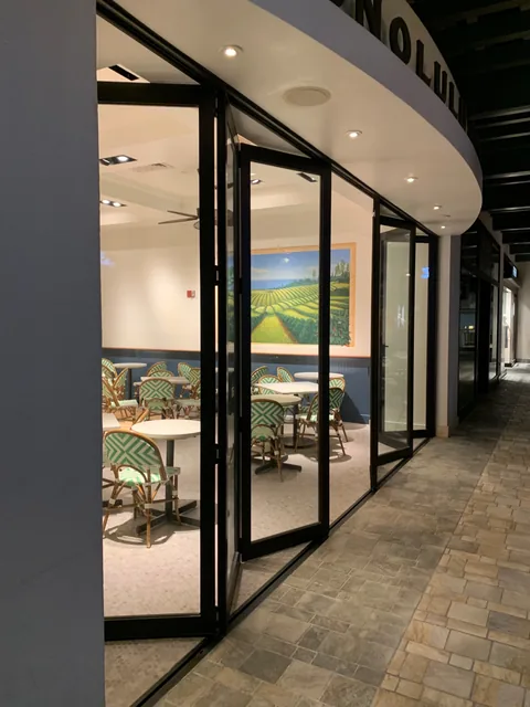 Folding glass doors at a curved coffee-shop entrance.