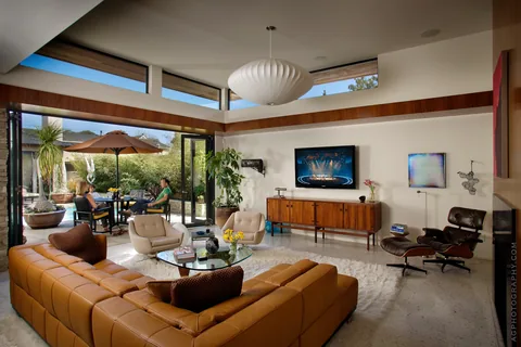 Thermally broken aluminum doors opening a living room toward a courtyard.