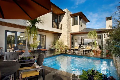 A pool courtyard bordered by folding glass doors.