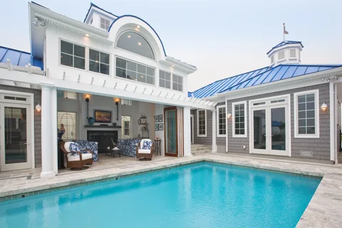 An exterior pool view of a home with clad folding doors.