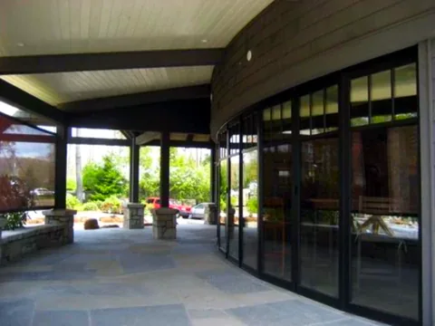 Aluminum folding doors following a curved restaurant frontage.