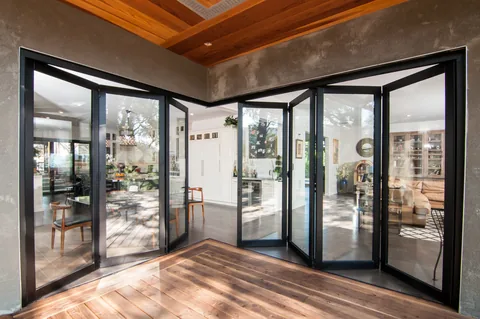 Exterior view of partly opened corner doors leading into a dining room.