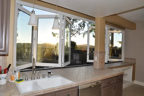 White folding windows above a kitchen sink.