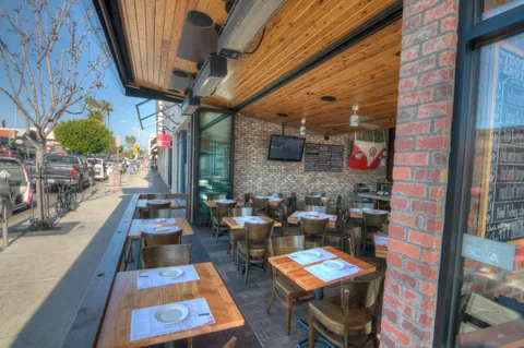 Folding windows connecting restaurant seating with a street-side counter.