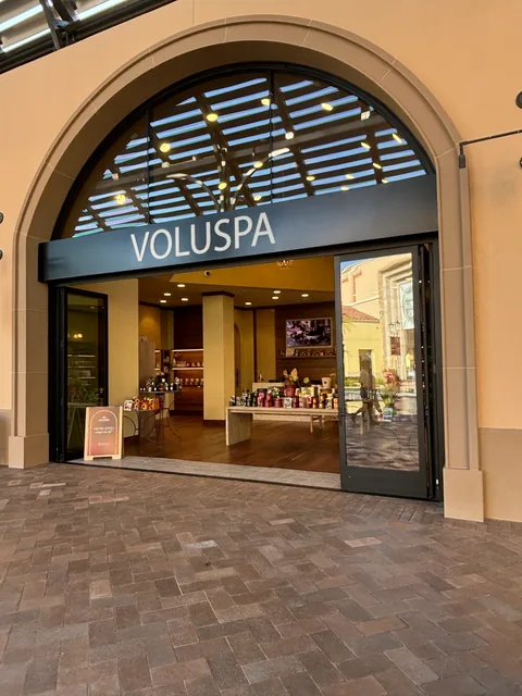 An arched retail entrance framed by dark aluminum glazing.